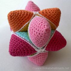 a crocheted stuffed animal made to look like an origami star with four different colors