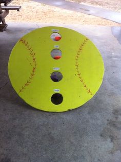 a yellow plate with baseballs on it sitting in the middle of a cement floor