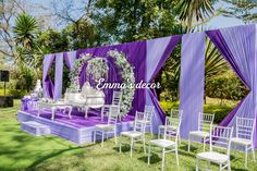 an outdoor wedding setup with purple and white decor