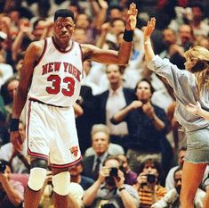 two basketball players high fiving each other in front of an audience