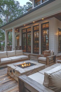 a fire pit sitting on top of a wooden deck next to couches and chairs