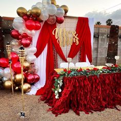 a red and gold themed party with balloons, table cloths, and decorations on the ground