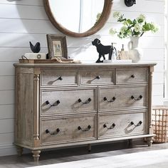 a dresser with drawers and a mirror on the wall