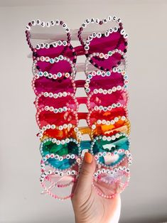 a hand holding up a pair of sunglasses made out of beads and plastic eyeglasses