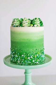 a cake with green frosting and sprinkles sitting on top of a plate