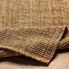 a close up view of the textured fabric on a wooden tablecloth or rug