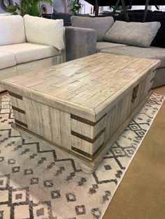 a coffee table made out of wooden crates on a rug in a room with couches