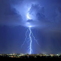 a lightning bolt is seen in the sky above a city