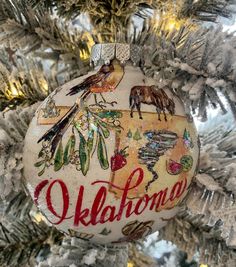 an ornament is hanging on a christmas tree with the word oklahoma painted on it