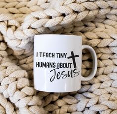 a white coffee mug with the words i teach tiny humans about jesus on it