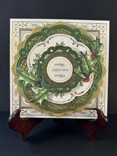 a christmas card with holly wreaths on it