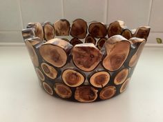 a bracelet made out of wood slices on a table with a white tile wall in the background