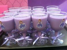 there are many glasses with purple liquid in them on the tray, and some have princesses on them