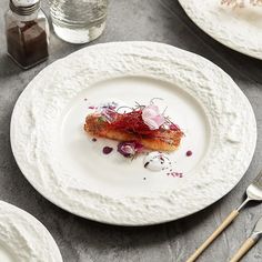 a white plate topped with food on top of a table next to utensils