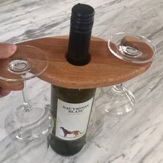 two wine glasses sitting on top of a wooden tray next to a bottle of wine