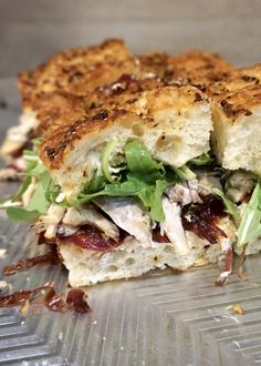 a sandwich cut in half sitting on top of a plastic tray covered in lettuce