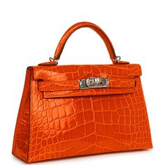 This tiny Kelly, in the Sellier style, is in Orange Poppy Shiny Alligator with gold hardware and has tonal stitching, two front straps with front toggle closure, single rolled handle and removable shoulder strap.The interior is lined with Orange Poppy lambskin and has one open pocket on the back wall.Collection: BOrigin: FranceCondition: New and never (plastic on hardware)Accompanied by: Hermès box, Hermès dustbag, shoulder strap, shoulder strap dustbag, felt, carebook, rainhat, CITES Measuremen Hermes Kelly Sellier, Kelly Sellier, Orange Poppy, Hermes Box, Alligator, Gold Hardware, Poppies, Dust Bag, Shoulder Strap