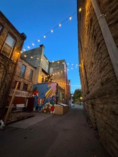 an alley way with buildings and string lights