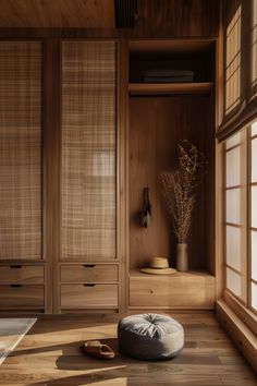 a room with wooden walls and flooring has a round pillow on the floor in front of it