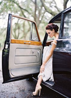 a woman sitting in the door of a car