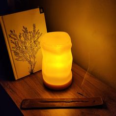 a lit candle sitting on top of a wooden table