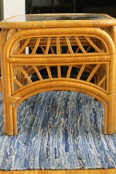 a wicker coffee table sitting on top of a blue rug