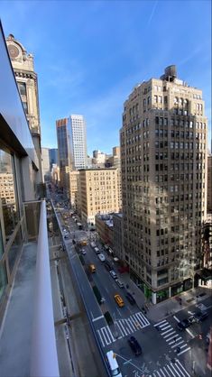 a city street filled with lots of traffic next to tall buildings on a sunny day