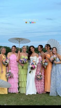 a group of women standing next to each other in dresses and holding umbrella's