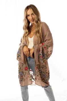 Nothing is more fun than a kimono covered in floral! This perfect layering piece features a sheer fabric in a longline silhouette with accents of crochet florals in multicolors along the hem and wide sleeves.Model is 5'4" and wearing a one size.100% PolyesterLength: 38 inBust Across: 25 inSleeve Length: 17 inSleeve Opening: 11 in Kimono And Jeans, Embroidered Kimono, Beautiful Kimonos, Print Kimonos, Bohemian Hippie, Wrap Cardigan, Cardigan Top, Weekend Wear, Sheer Fabric