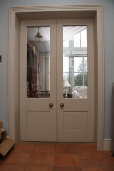 two white double doors in front of a blue wall