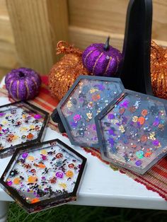 there are three small trays on the table with halloween decorations in front of them