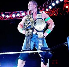 a man standing on top of a wrestling ring with his hands in his pockets,