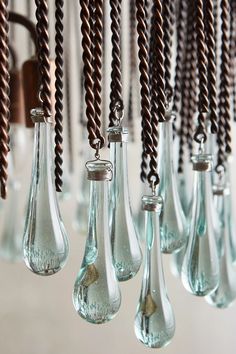 several glass vases are hanging from the ceiling