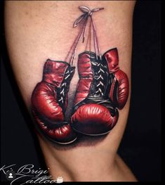 a tattoo with two boxing gloves hanging from it