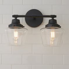 two light fixtures mounted on a white tiled wall