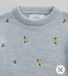 a blue sweater with yellow flowers on it