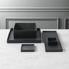 black square dishes and trays on a white marble table