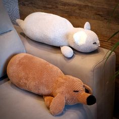 two stuffed animals are sitting on a couch