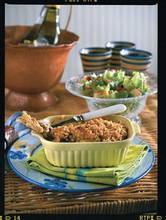 a table topped with plates and bowls filled with food on top of each other next to salad