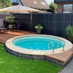 an above ground swimming pool with decking and umbrellas in the back yard area