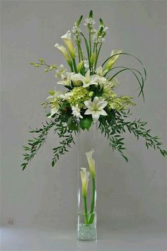 a vase filled with white flowers and greenery on top of a table next to an instagram page