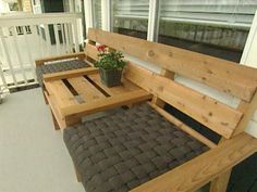 a wooden bench sitting on top of a porch next to a potted plant and window