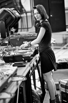 a woman standing at a table with dj equipment