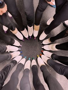 a group of people standing in a circle with their feet on each other's ankles