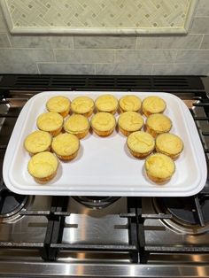 cupcakes sitting on top of a white platter in front of an oven