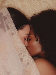 two women laying in bed under a veil