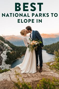 a bride and groom kissing on top of a mountain