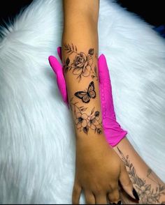 a woman's arm with flowers and butterflies on it