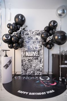 a birthday party with black balloons and silver confetti on the floor in front of a sign that says, happy birthday dana