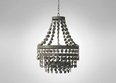 a metal chandelier with coins hanging from it's center and chain attached to the bottom